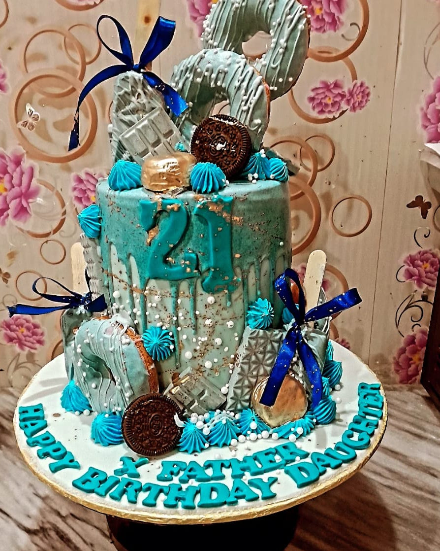 Decorative cake with teal and blue theme on a floral background