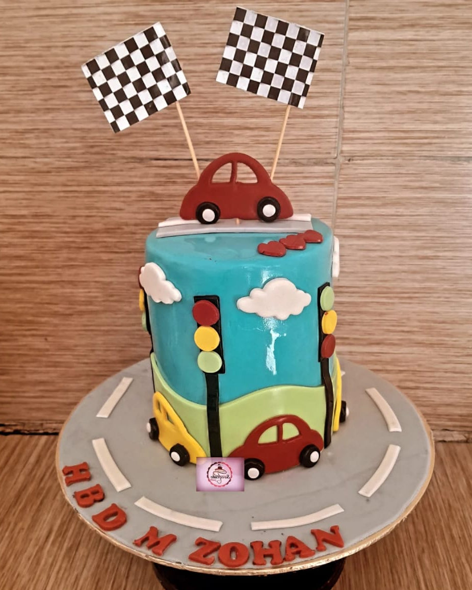 Children's birthday cake with traffic light and car design on a wooden surface