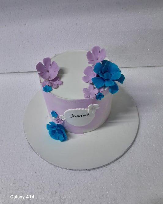 Small purple cake with floral decorations on a white surface