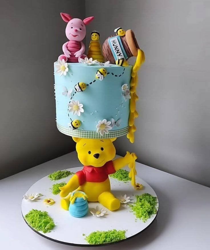Cake decorated with Winnie the Pooh and friends on a gray background